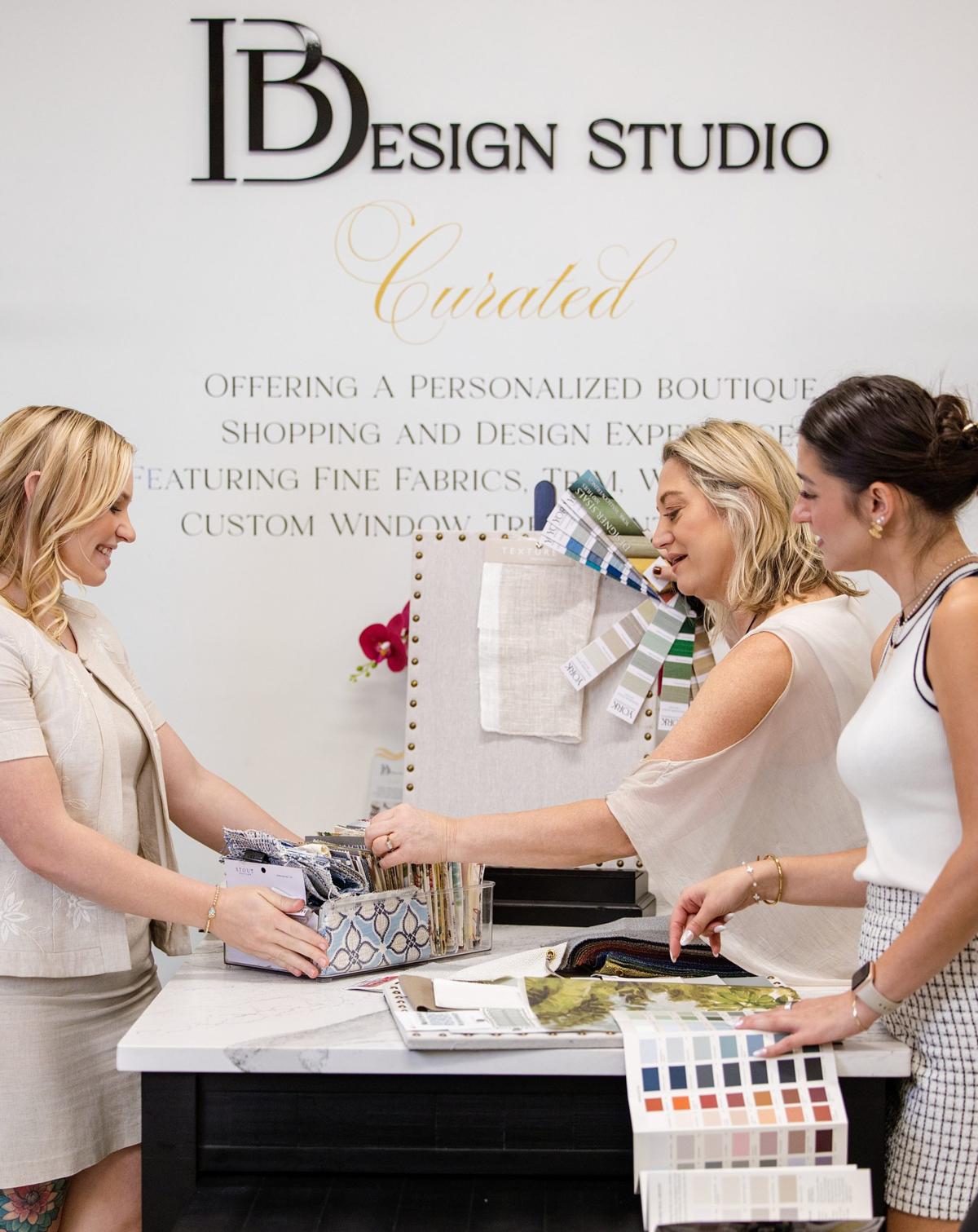 Team branding photo of three interior designers sorting fabric swatches at DB Design Studio