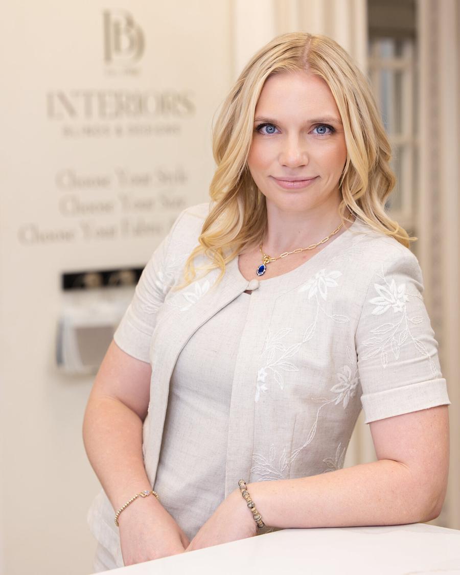 Business headshot of a blonde woman in a white embroidered jacket in her interiors showroom