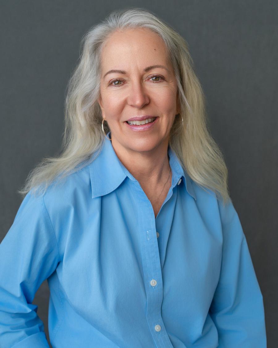 Headshot of a smiling woman with long silver hair in a blue shirt, Tyrone, GA studio