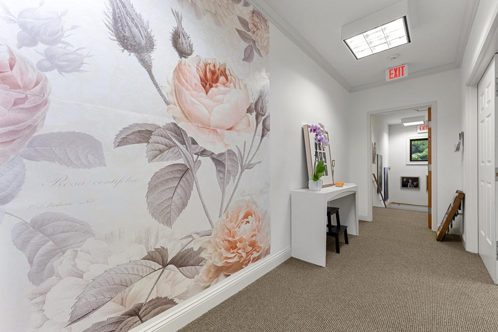 Hallway with a large rose wall mural and a white console