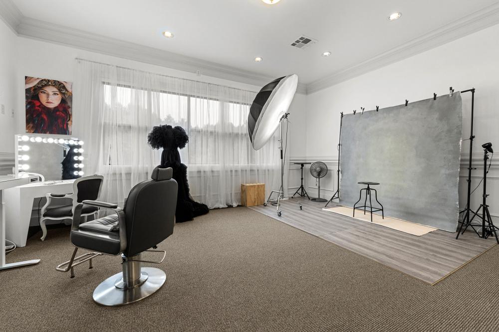 Makeup station with a lighted mirror and styling chair at the Tyrone, GA photo studio