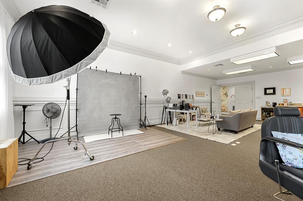 Shooting set with a large umbrella light, backdrop and the lounge behind