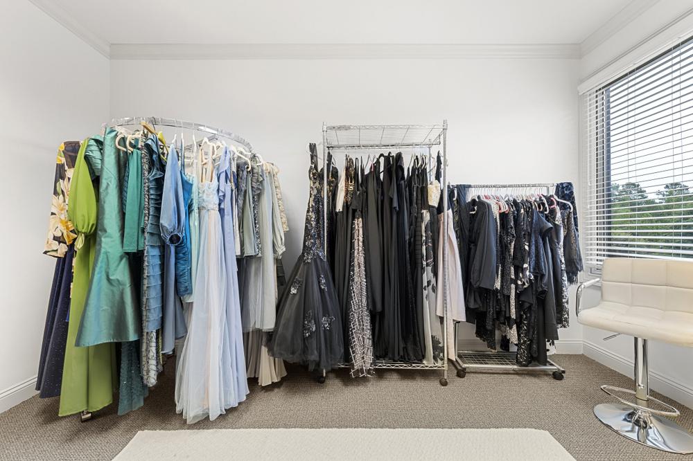 Wardrobe racks of dresses in every color and size beside a bright window