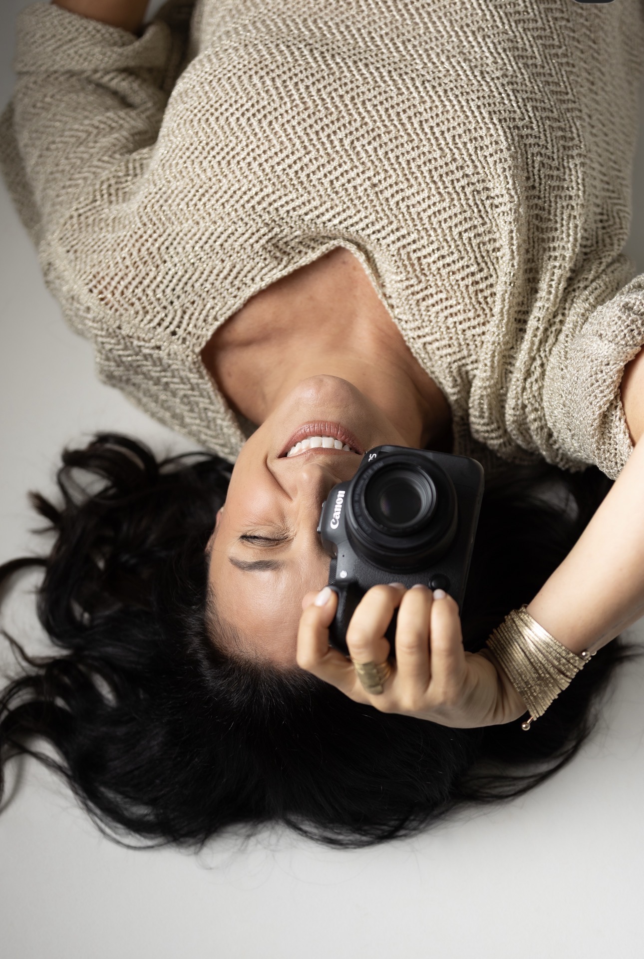 Leticia Andrade lying upside down and smiling behind her camera